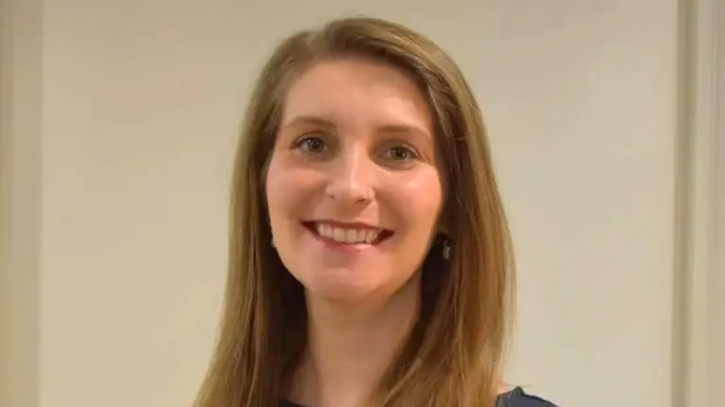 Sammie smiling in front of a neutral background