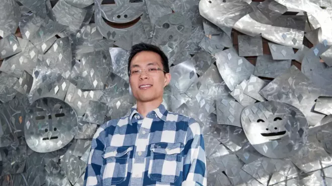 Stanley smiling in front of a sculptural background